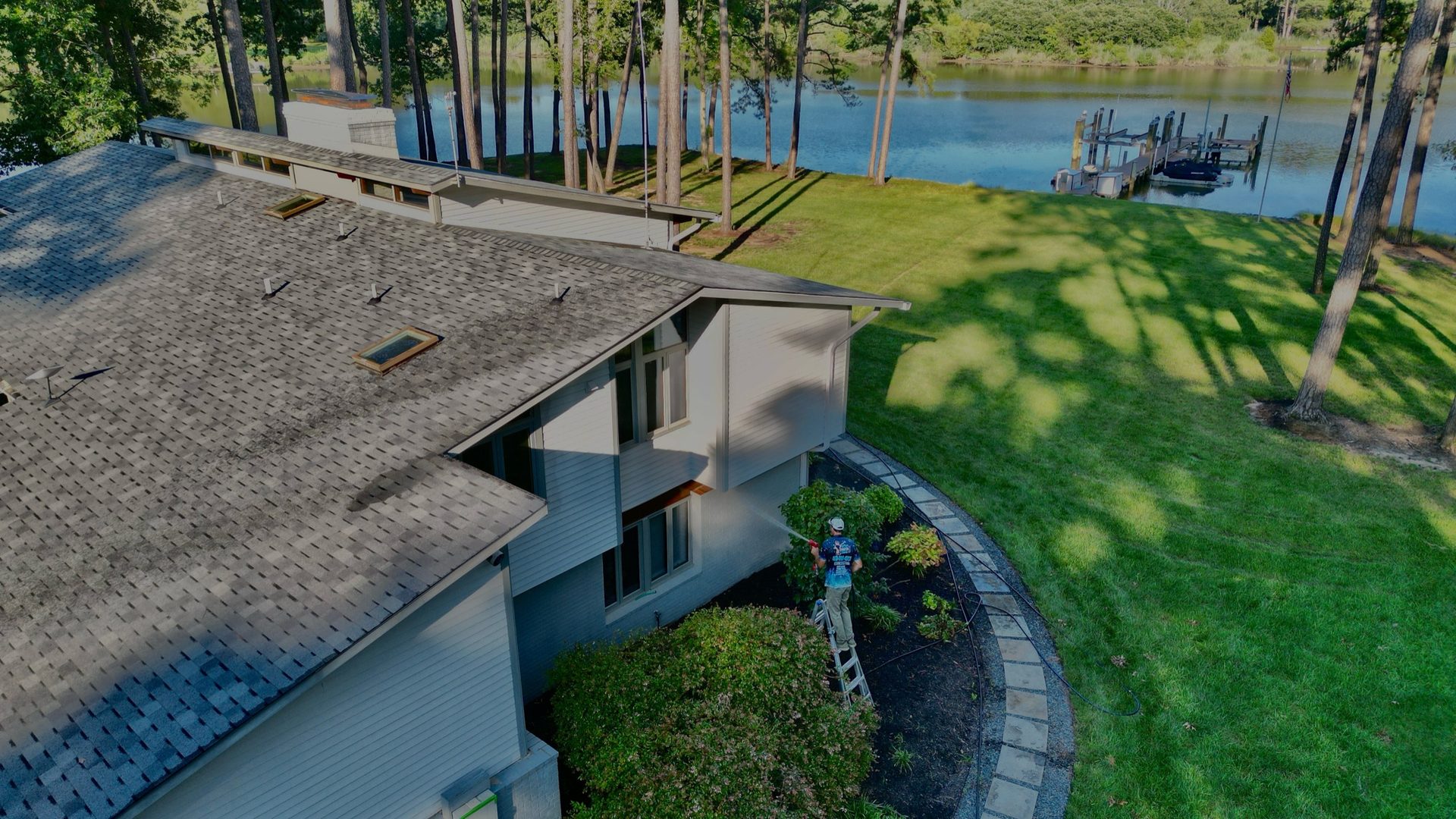 Drone shot showing our technician soft washing the exterior of a waterfront home in Talbot County.