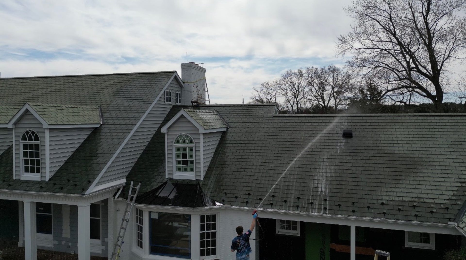 Coastal Shine technician soft-washing a shingle roof on a large home in Easton MD on Maryland's Eastern Shore