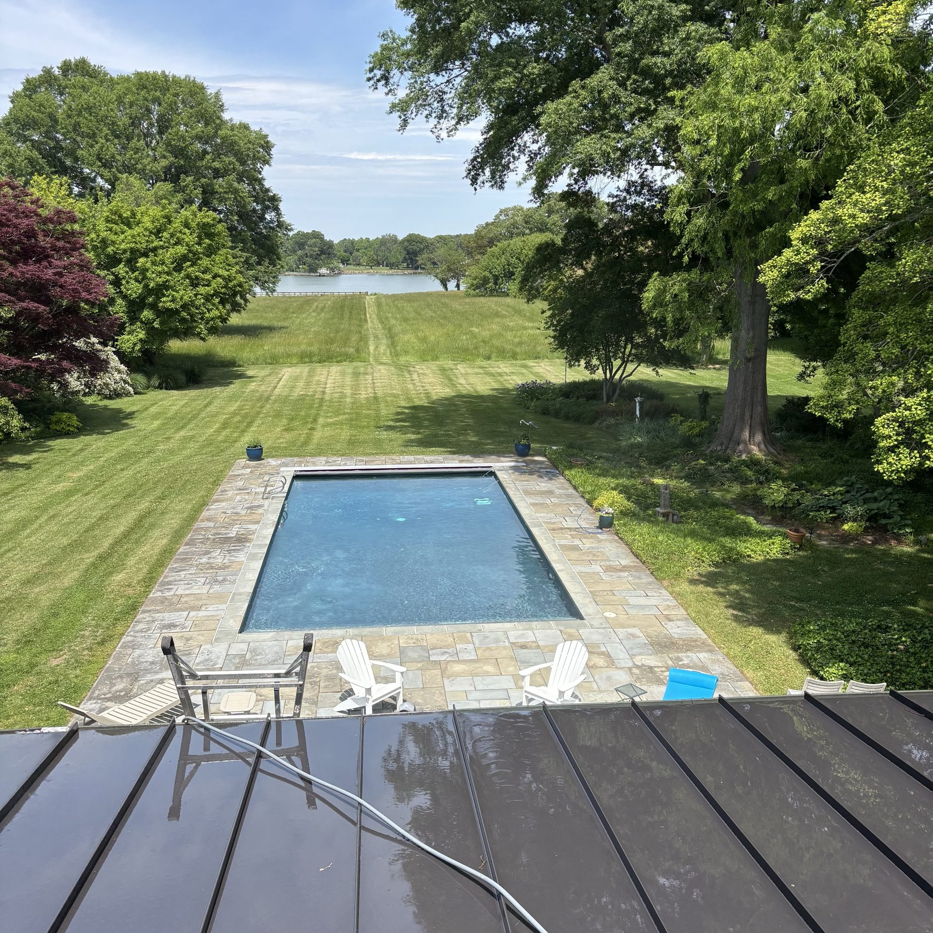Aerial view of a cleaned flagstone in-ground pool deck overlooking the water at a waterfront estate near Easton MD on the Eastern Shore