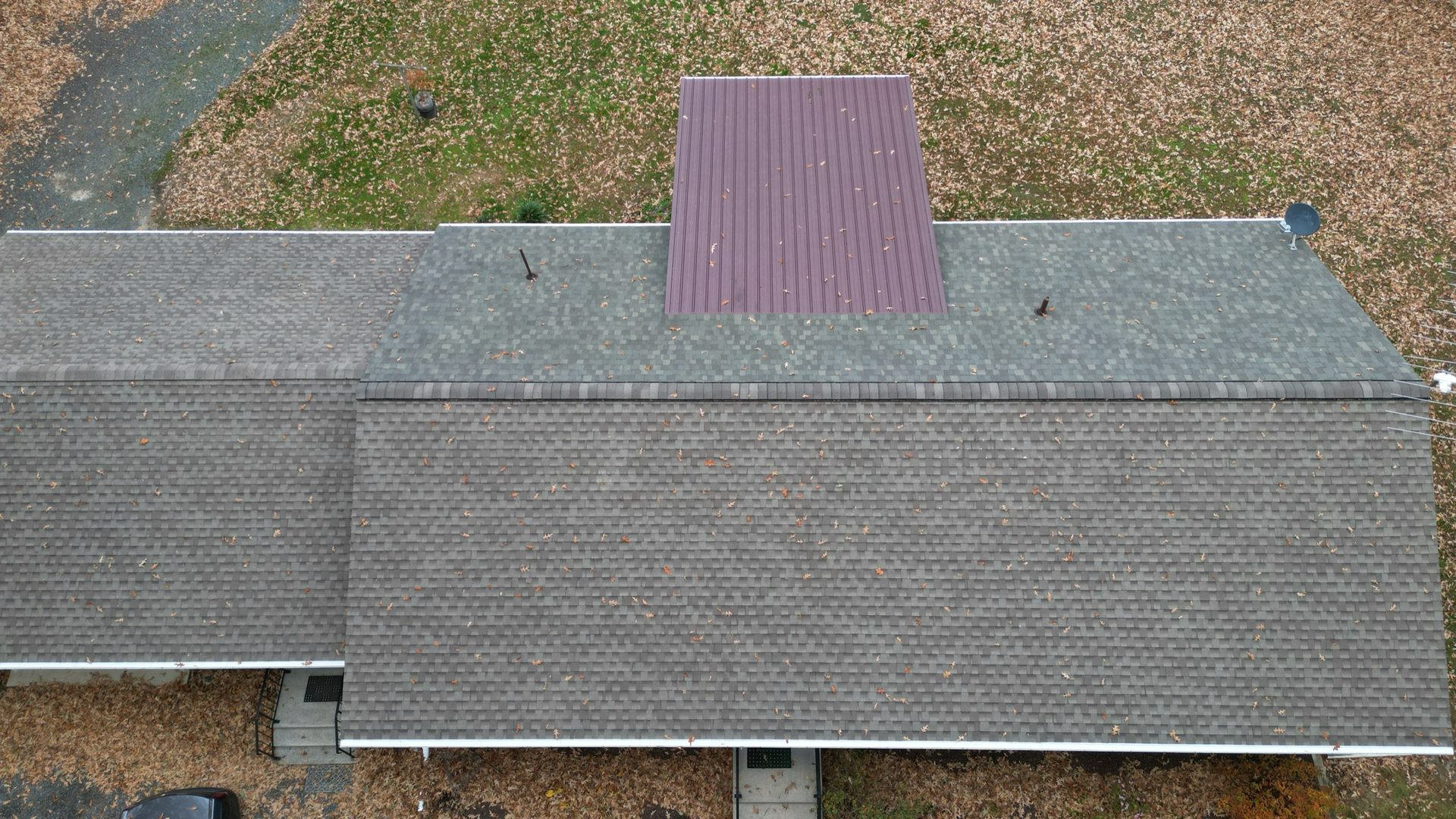 Aerial drone view of a cleaned residential shingle roof with a red metal accent section on a home in Easton MD on Maryland's Eastern Shore